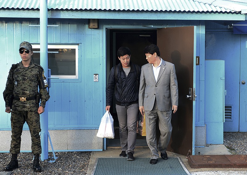 
              In this photo provided by the South Korean Unification Ministry, South Korean Won Moon Joo, center, who has a permanent resident status in the United States, is escorted by a South Korean official at the border village of Panmunjom in Paju, South Korea, Monday, Oct. 5, 2015. North Korea freed a South Korean national who'd been attending New York University before his detention, Seoul officials said Monday, in a possible sign Pyongyang wants better ties with rival Seoul and may back away from a recent threat to launch a long-range rocket later this month. (The South Korean Unification Ministry via AP)
            