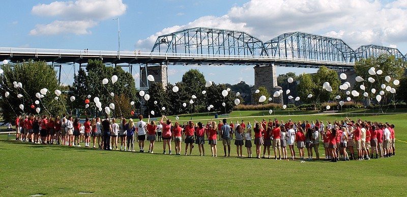Dozens of Baylor, McCallie and GPS students release silver balloons in honor of the Baylor swimmer Monday afternoon at Coolidge Park.