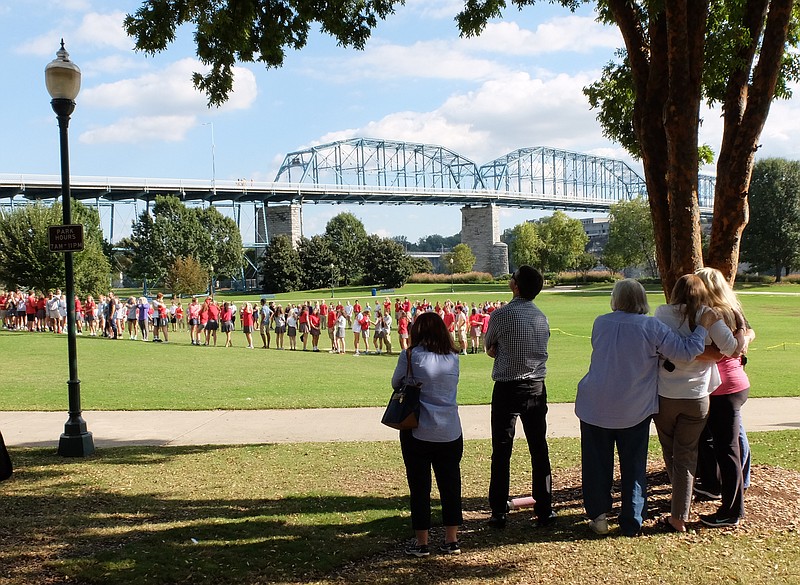 People watch from afar as dozens of Baylor, McCallie and GPS students watch released silver balloons at Coolidge Park.