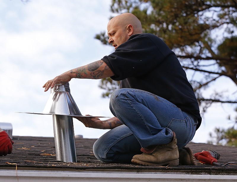 
              FILE - In this Nov. 20, 2014 file photo, David Mayer, owner of Mayer's Heating Service, installs a roof vent pipe as part of a new direct vent furnace installation in East Wareham, Mass. Heating bills should drop this winter for most U.S. households, thanks to a combination of lower energy prices and warmer weather across most of the country, the U.S. Energy Department said in its annual prediction Tuesday, Oct. 6, 2015. (AP Photo/Stephan Savoia, File)
            