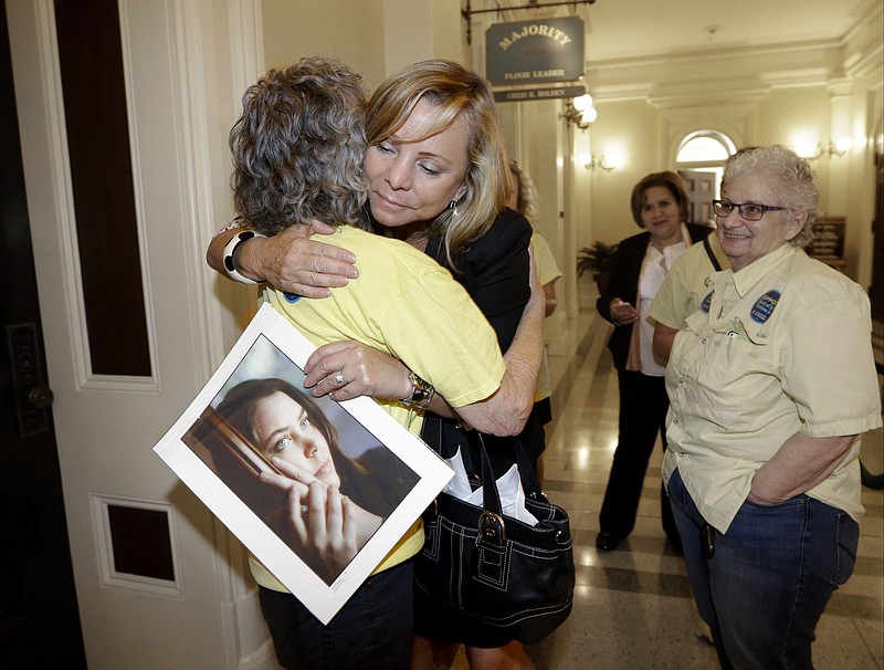 
              FILE - In this Sept. 9, 2015, file photo, Debbie Ziegler holds a photo of her late daughter, Brittany Maynard, as she receives congratulations from Ellen Pontac, left, after a right-to die measure was approved by the state Assembly in Sacramento, Calif. California will become the fifth state to allow terminally ill patients to legally end their lives using doctor-prescribed drugs after Gov. Jerry Brown announced Monday, Oct. 5, 2015 he signed one of the most emotionally charged bills of the year. (AP Photo/Rich Pedroncelli, File)
            