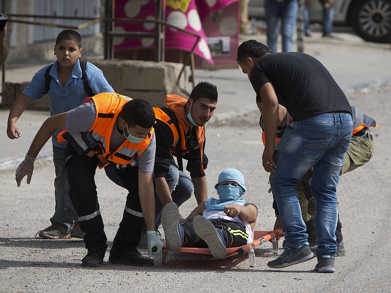 
              Palestinians carry an injured man during clashes with Israeli troops at Qalandia checkpoint between Jerusalem and the West Bank city of Ramallah, Tuesday, Oct. 6, 2015. A new generation of angry, disillusioned Palestinians is driving the current wave of clashes with Israeli forces: They are too young to remember the hardships of life during Israel's clampdown on the last major uprising, and after years of nationalist Israeli governments many have lost faith in statehood through negotiations and believe Israel only understands force. (AP Photo/Majdi Mohammed)
            
