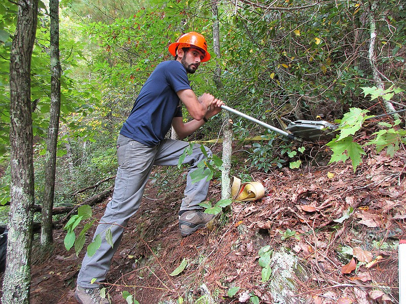 David Cohen of the Southern Appalachian Wilderness Stewards uses a griphoist to tighten a wire rope that will be used to lift a heavy load of rocks from one section to another of the Bald River Trail.