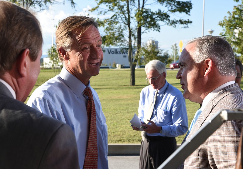 Tennessee Gov. Bill Haslam talks to lawmakers from the greater Chattanooga area following a news conference about the commitment the state has to Volkswagen on Wednesday outside the Tennessee Department of Transportation Management Center in Chattanooga. Representative Kevin Brooks, right, of Cleveland, listens. The governor had just come from visiting with workers inside the plant Wednesday afternoon.