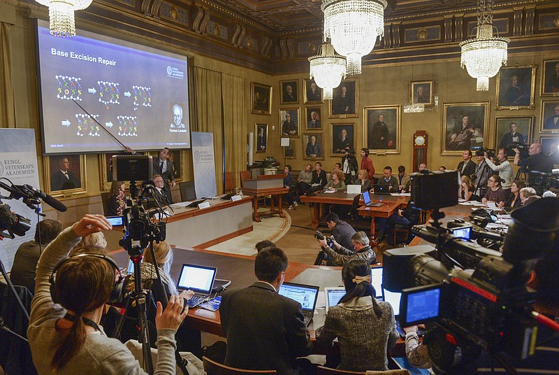 
              Members of the media listen as professor Claes Gustafsson, standing by the screen, explain the reasons for the prize during a press conference at the Royal Swedish Academy in Stockholm, Wednesday, Oct. 7, 2015. Sweden's Tomas Lindahl, American Paul Modrich and U.S.-Turkish scientist Aziz Sancar won the Nobel Prize in chemistry on Wednesday for "mechanistic studies of DNA repair." (Fredrik Sandberg/TT News Agency via AP) SWEDEN OUT
            