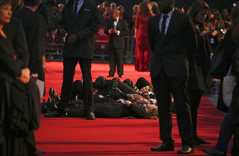 
              In an echo of the suffragettes' direct-action tactics, protesters from anti-domestic violence group Sisters Uncut got past barriers and lay on the red carpet carrying signs saying "Dead Women Can't Vote," and said on Twitter they were continuing the suffragettes' struggle for women's equality, as they protest at the glitzy festival premiere for the film, Suffragette, in London, Wednesday, Oct. 7, 2015.  The film portrayal of women's suffrage, Suffragette is the opening gala of the London film festival. (Photo by Joel Ryan/Invision/AP)
            