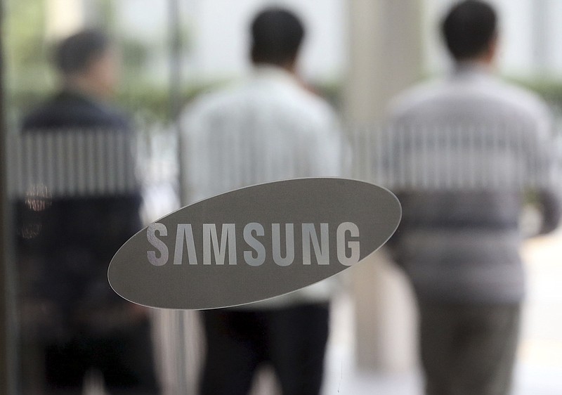 
              People walk by the logo of Samsung Electronics Co. near its office in Seoul, South Korea, Wednesday, Oct. 7, 2015. Samsung Electronics announced a forecast-beating profit for the third quarter Wednesday, sending its share price up more than 7 percent, but analysts said strong component sales and favorable currency exchange rates masked persistent weakness in its smartphone business. (Choi jae-gu/Yonhap via AP) KOREA OUT
            