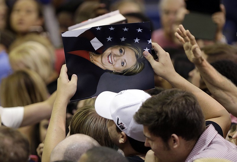 Supporters hold a photo of Democratic presidential candidate Hillary Rodham Clinton hoping to get it autographed following a speech by Clinton at a campaign event at Broward College on Friday, Oct. 2, 2015, in Davie, Fla.