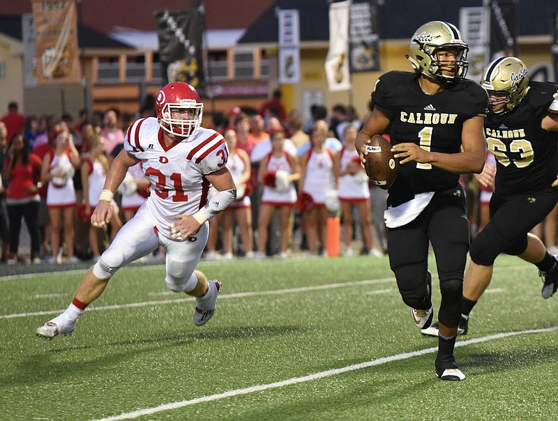 Calhoun's Kaelan Riley (1) rolls out to throw in first half action with Dalton's Matt Cook (31) in pursuit.