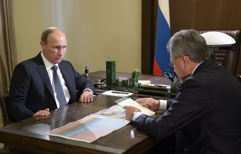 Russian President Vladimir Putin, left, listens to Defense Minister Sergei Shoigu during their meeting in the Bocharov Ruchei residence in the Black Sea resort of Sochi, Russia, on Wednesday. Russia on Wednesday morning carried out 26 missile strikes from four warships of its Caspian Sea flotilla.
