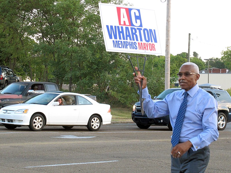 
              FILE - In this  Friday, Sept. 25, 2015 file photo, Memphis Mayor A C Wharton Jr. holds a campaign sign on a street corner in Memphis, Tenn.  Wharton Jr. has conceded Memphis' mayoral election to a city council member who is now poised to become the city's first white mayor in almost a quarter-century. Wharton's concession to councilman Jim Strickland came late Thursday, Oct. 8,  before complete results for the nonpartisan election were posted.  (AP Photo/Adrian Sainz)
            