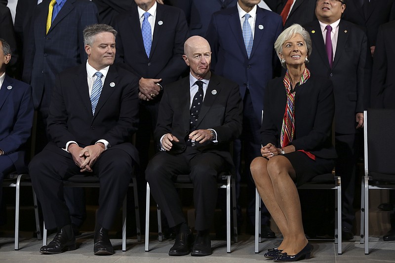 
              International Monetary Find (IMF) Managing Director Christine, right, sits next to Glenn Robert Stevens, Governor of the Reserve Bank of Australia, center, and  Mathias Cormann, Minister for Finance of Australia, before a group picture with Finance Ministers and Central Bank Governors from the G20 in Lima, Peru, Thursday, Oct. 8, 2015. The world's finance ministers and central bankers are in Lima for the joint annual meetings of the World Bank and IMF that run through Sunday. (AP Photo/Geraldo Caso Bizama)
            