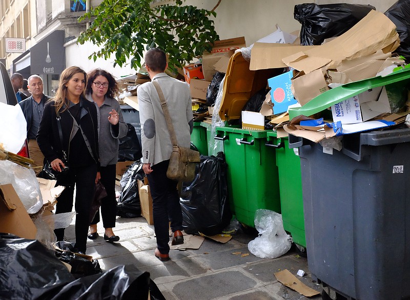 
              People walk past a pile of garbage during the fourth day of a garbage collectors strike in Paris, France, Thursday, Oct. 8, 2015. Trash is piling up on Paris streets because of a strike by garbage collectors angry over wage and career stagnation. (AP Photo/Jacques Brinon)
            