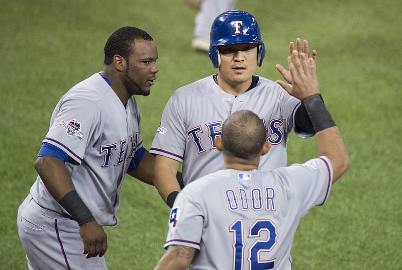 Texas Rangers, from left to right, Hanser Alberto, Shin-Soo Choo, and Rougned Odor celebrate Choo scoring during the first inning in Game 2 of baseballs American League Division Series in Toronto on Friday, Oct. 9, 2015. 