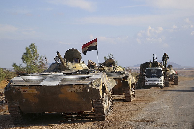 In this photo taken on Wednesday, Oct. 7, 2015, Syrian armored vehicles get ready to move near the village of Morek in Syria.