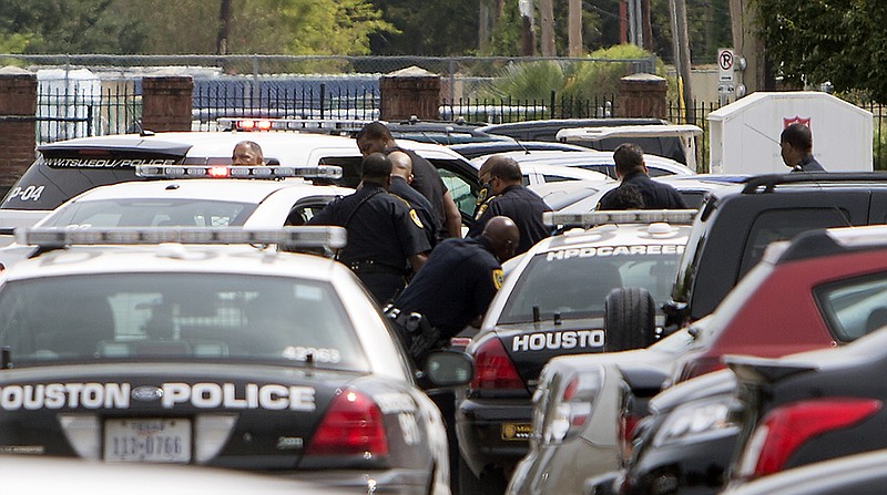 Authorities search for a man as they investigate a shooting at Texas Southern University, Friday, Oct. 9, 2015, in Houston. A student was killed and another person was wounded in a shooting outside a student-housing complex on Friday, and police have detained at least two people, authorities said. (Cody Duty/Houston Chronicle via AP) MANDATORY CREDIT