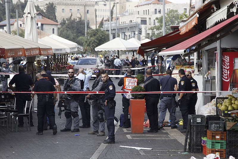 
              Israeli policemen stand by the body of a Palestinian at the scene of an stabbing attack in Jerusalem Saturday, Oct. 10, 2015. A Palestinian teenager stabbed two Israelis in Jerusalem Saturday before being shot dead by police forces, the latest in a series of stabbing attacks against civilians and soldiers that have spread across Israel and the West Bank in the past week. (AP Photo/Mahmoud Illean)
            