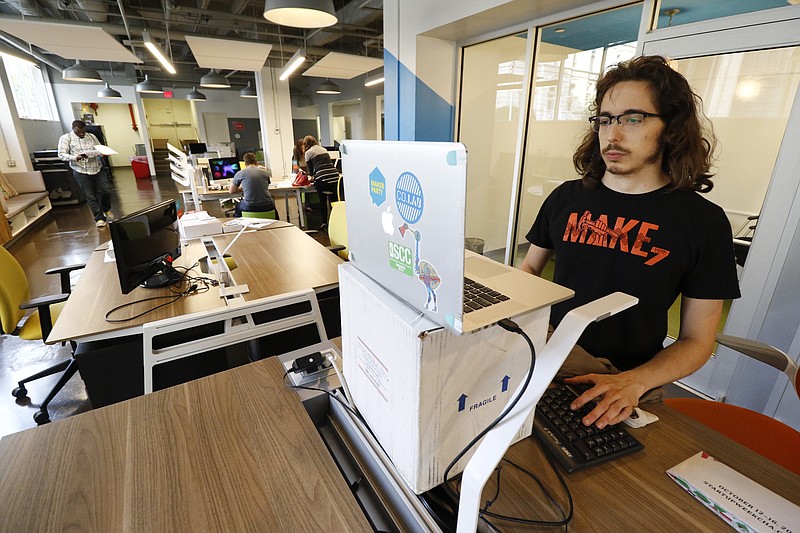 Staff Photo by Dan Henry / The Chattanooga Times Free Press- 10/9/15. Quantum Potato, right, works on developing a new iPhone app in CoLab's new space on the first floor of the Edney Building off of E.11th Street in downtown Chattanooga on Friday, October 9, 2015. 