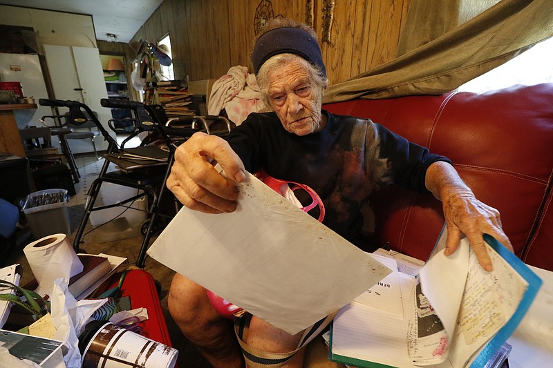 Serpentfoot, an 82-year-old Georgia woman on the Chattooga-Floyd County line, goes through a stack of old papers in her home on a recent day.