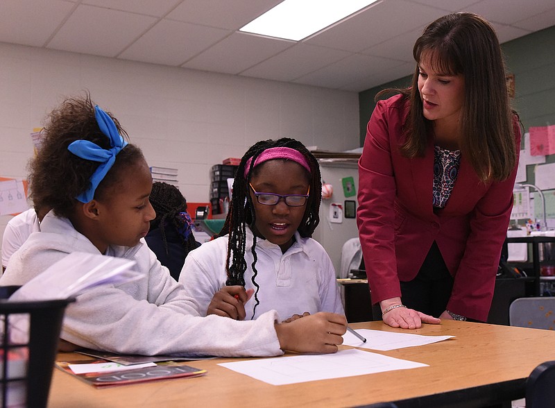 Tennessee Education Commissioner Candice McQueen, right, talks with sixth-grade English Language Arts students Deshay Smith, left, and Carlotta Sawyer during a March visit to Dalewood Middle School.
