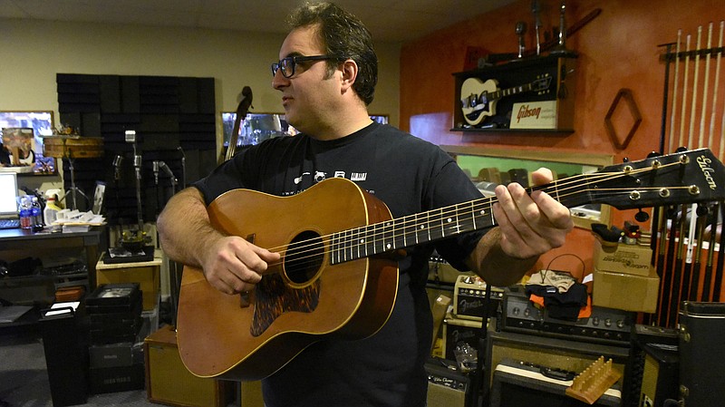 Brad Putt plays a 1941 Gibson J35 at his store, Main Stage Music, on Wednesday, Oct. 7, 2015, in Dayton, Tenn. 
