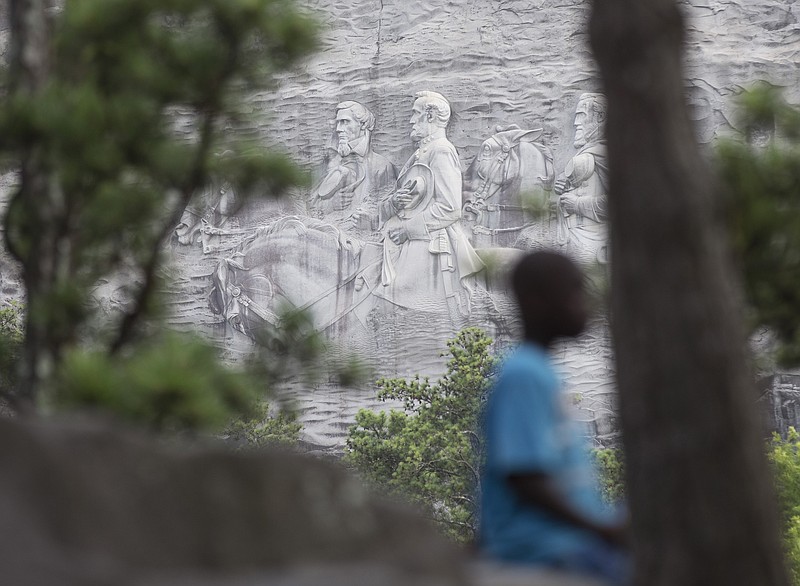
              FILE - In this Tuesday, June 23, 2015, file photo, a youngster plays on a rock in front of the carving on Stone Mountain, in Stone Mountain, Ga. The carving depicts confederates Robert E. Lee, Jefferson Davis and Stonewall Jackson. Planning is underway to place a replica of the Liberty Bell atop Stone Mountain as a memorial to the Rev. Martin Luther King Jr. that recalls a famous line from his “I Have a Dream” speech, officials say. (AP Photo/John Bazemore, File)
            