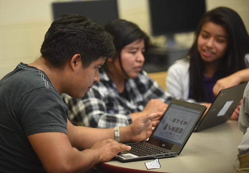 Edilzar Garcia, left, and Alicia Bautista, center, and Gasive Aguilar work during a Tech Goes Home class Wednesday, September 30, 2015 at East Lake Academy.