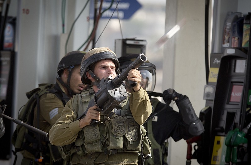 
              An Israeli soldier fires a tear gas canister during clashes with Palestinian protesters near Ramallah, West Bank, Monday, Oct. 12, 2015. Recent days have seen a series of stabbing attacks in Israel and the West Bank that have wounded several Israelis. Past weeks have also seen violent demonstrations in the West Bank and Gaza, and at least 16 Palestinians have been killed by Israeli forces. (AP Photo/Majdi Mohammed)
            