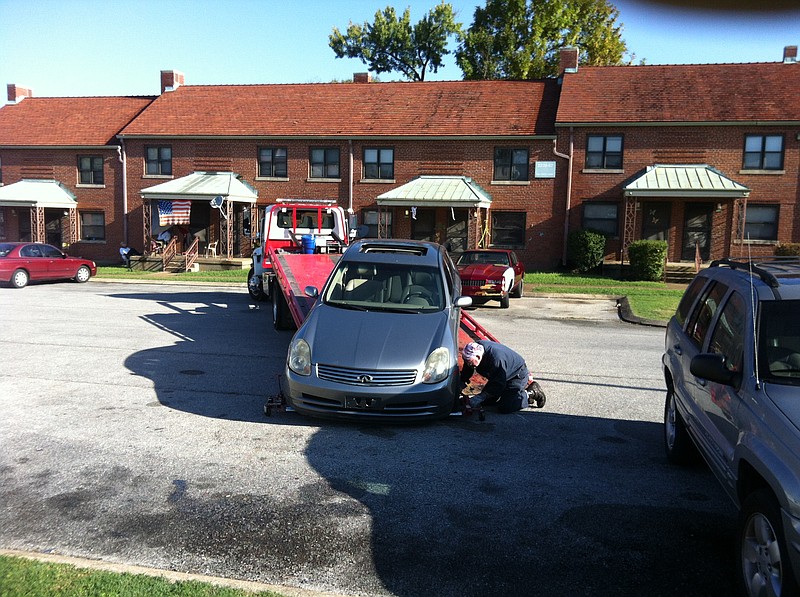 City employee Ed Blaylock picks up a stolen car from a parking lot at the East Lake Courts on Tuesday morning, Oct. 13, 2015, in Chattanooga, Tenn. The car is believed to have been used during an 8 a.m. incident on 38th Street near the Bethlehem Center. 