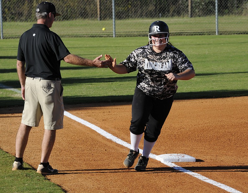 Rounding third base, Ridgeland pitcher Morgan Crawford is congratulated by Coach Richie Wood after a two-run shot over the left field fence in Wednesday's Class AAAA first-round softball playoff against St. Pius X in Rossville. The home run pushed the score to 4-0, in the first game of a double-header.