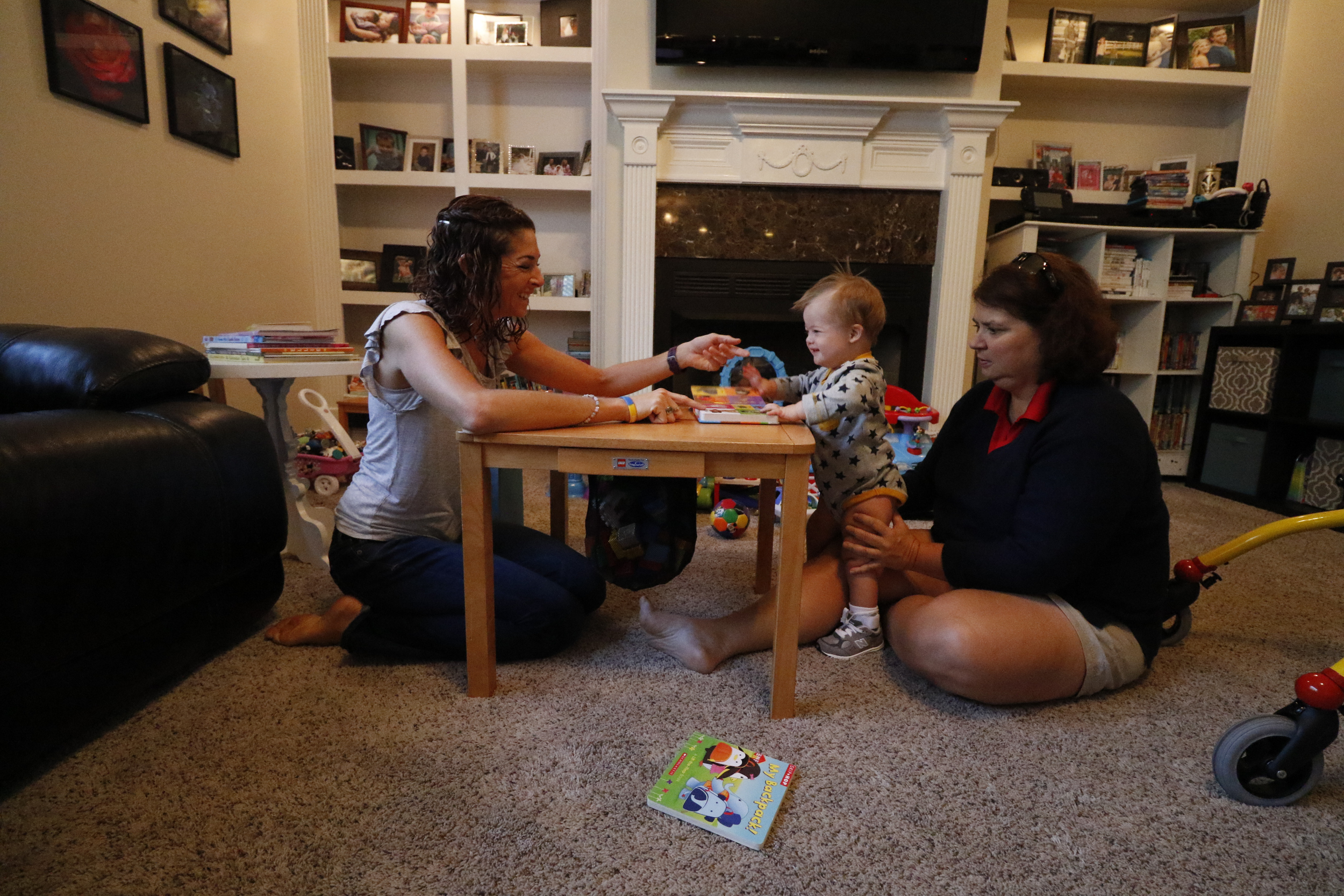 Jessica Cochran, left, and her 19-month-old son Maverick work with physical therapist Kilbrey Fowler at the Cochran residence to build Maverick's leg and trunk strength.