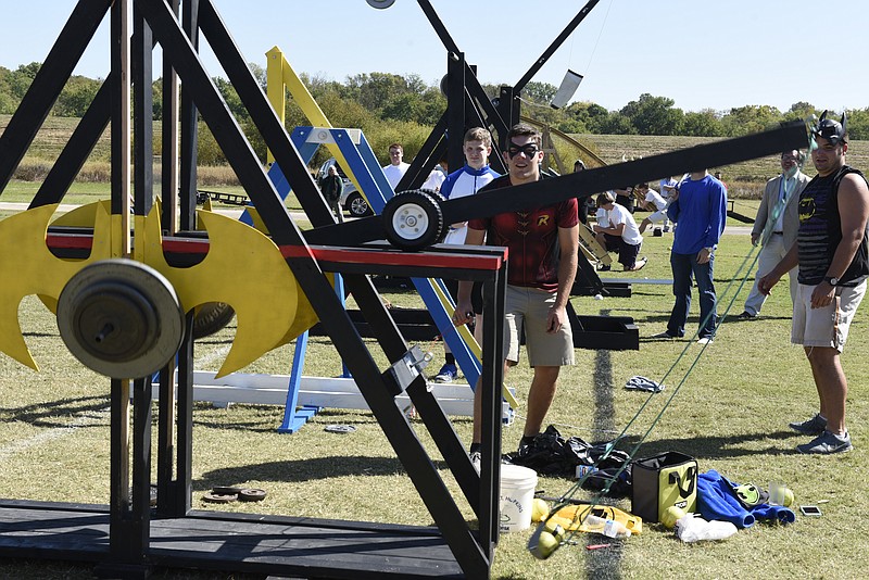 Jordan Raines, center, and Eli Legg of the Dark Knights launch a softball from their team's trebuchet as Boyd Buchanan physics students compete in the school's 10th annual trebuchet and catapult competition on Wednesday, Oct. 14, 2015, in Chattanooga, Tenn. 