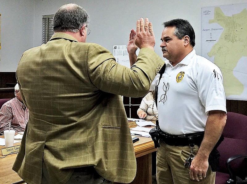 Jasper City Attorney Mark Raines (left) swears in new police Chief Billy Mason.