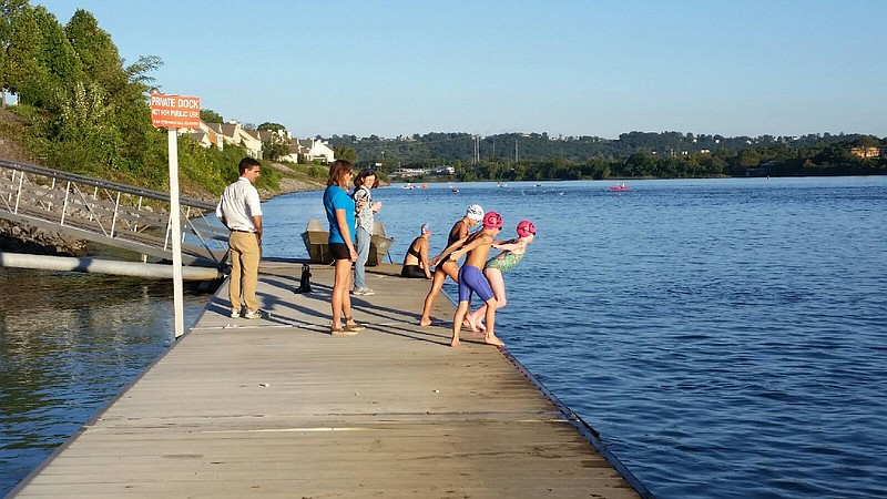 Tilleigh Nazor-Comer, 8, center, jumps in the Tennessee River with Scout Chapin, 9, at left, and Bec Fitzsimmons, 8, to compete in the RiverRocks 1/2-mile Snail Darter Sprint.