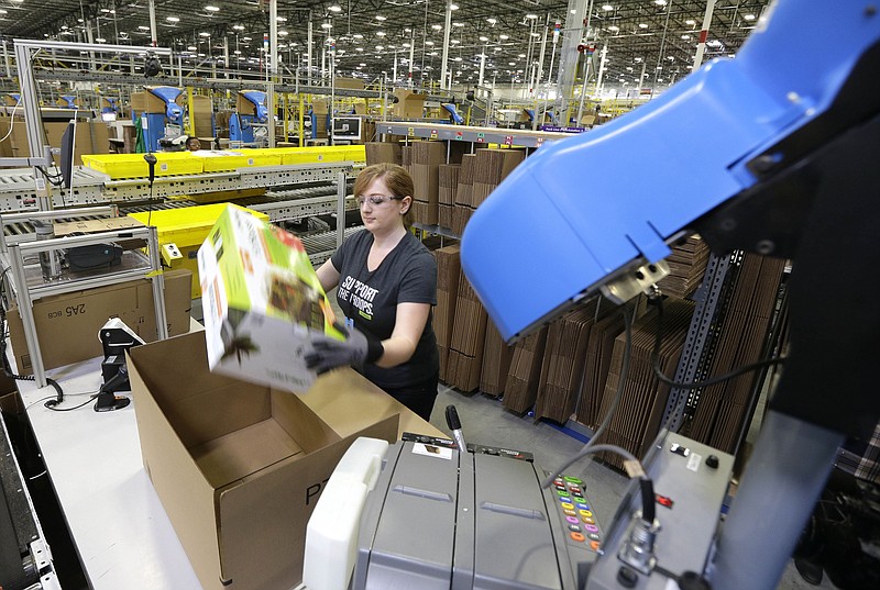 
              FILE - In this Feb. 13, 2015 file photo, a worker places an item in a box for shipment during a media tour of the new Amazon.com fulfillment center in DuPont, Wash. The center is one of 50 around the country and three in the Puget Sound area that process and ship Amazon customer orders using a mix of robotic technology and human employees. (AP Photo/Ted S. Warren, File)
            