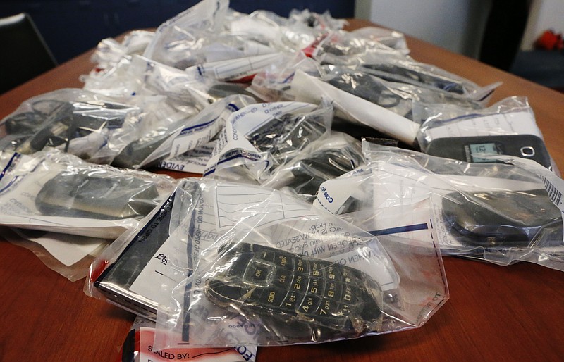 Confiscated cell phones are displayed during a news conference Thursday, Sept. 24, 2015, in Atlanta. Gangs at some Georgia prisons have been using cellphones to traffic drugs, smuggle in contraband, steal identities and, in at least one case, to arrange a violent attack on an inmate suspected of snitching, according to federal indictments unsealed Thursday that target a dozen people who officials say were involved in two prison-based crime rings.