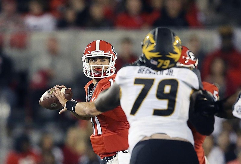 Georgia quarterback Greyson Lambert passes as Missouri defensive lineman Terry Beckner Jr. (79) brings pressure in the first half of Saturday night's Southeastern Conference matchup in Athens, Ga.