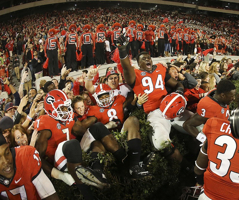 Georgia players from left; Lorenzo Carter (7) Shaun McGee (8) and Michael Barnett (94) celebrate with fans after defeating Missouri 9-6 in an NCAA college football game Saturday, Oct. 17, 2015, in Athens, Ga.
