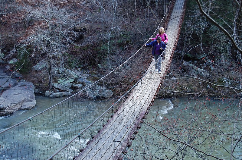 Fall Creek Falls State Park visitors Rhonda Bigler, foreground, and Deborah Nash cross a swinging bridge for a view of Cane Creek in 2013.