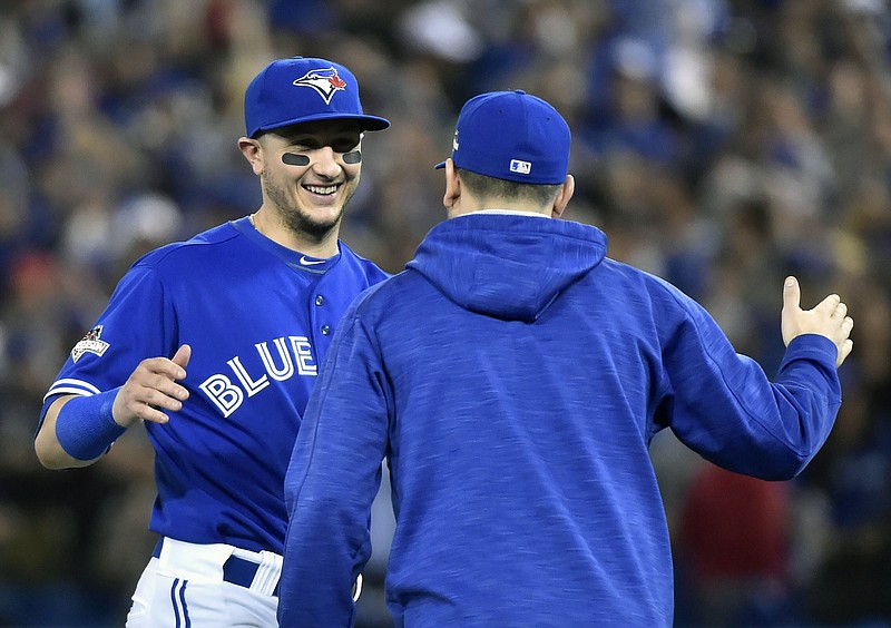 Toronto Blue Jays' Troy Tulowitzki celebrates with pitcher Marco Estrada after their 7-1 win over the Kansas City Royals in Game 5 of baseball's American League Championship Series on Wednesday, Oct. 21, 2015, in Toronto. (Nathan Denette/The Canadian Press via AP) MANDATORY CREDIT