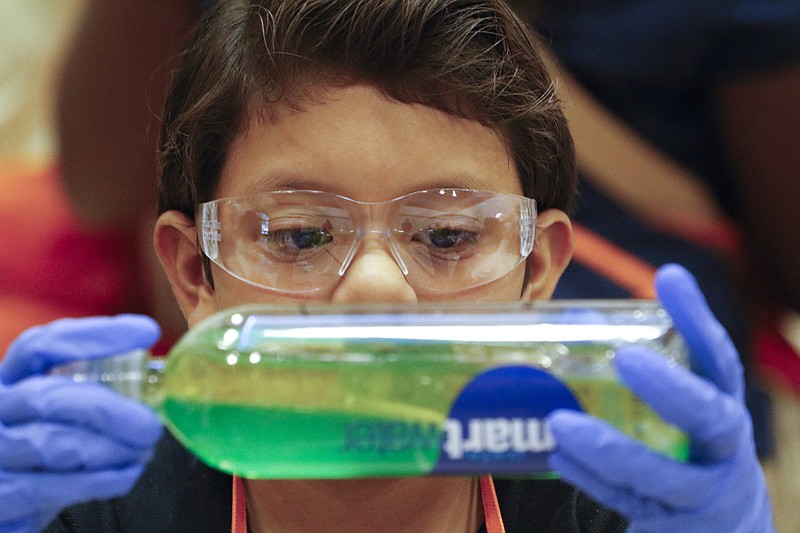 Staff Photo by Dan Henry / The Chattanooga Times Free Press- 10/22/15. Stalin Mayorga watches the water and oil separate while creating a lava lamp during the BASF Kids' Lab at Orchard Knob Elementary School on Thursday, October 22, 2015. 