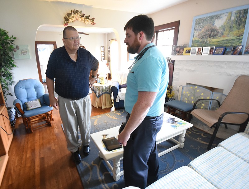 Dr. Matthew Hitchcock, right, talks one of his patients on a house call recently. Hitchcock is opening his Direct Primary Care facility near Highland Plaza in a former financial institution structure.