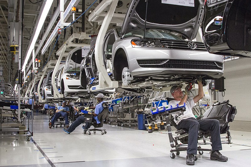 In this July 12, 2013, file photo, employees at the Volkswagen plant in Chattanooga, Tenn., work on the assembly of a Passat sedan.