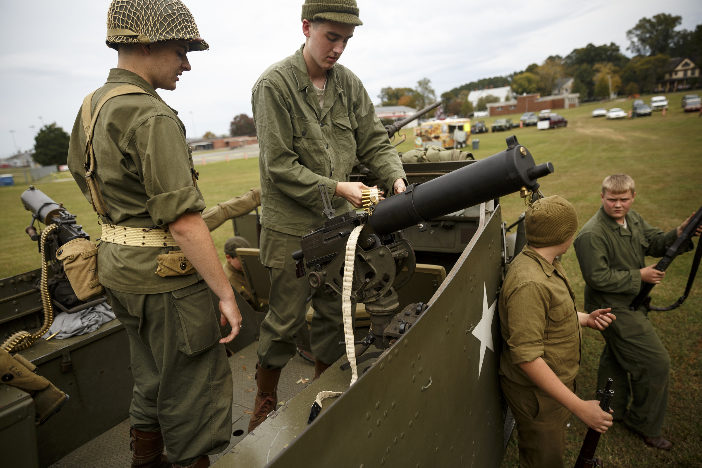 Justin Koenig, center, and James Decker, left, load a 1917 Browning machine gun mounted to a M3A1 scout car with blanks for a firing demonstration as Jonathan Martin, right, and Malachi Salas stand nearby at the 6th Cavalry Museum's 6th annual Remembering Our Heroes event on Saturday, Oct. 24, 2015, in Fort Oglethorpe, Ga. The event featured one World War II battle re-enactment, but the second re-enactment was changed to a firing demonstration after lower spectator turnout.