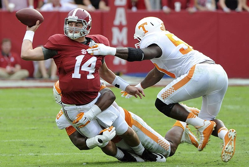 Alabama quarterback Jake Coker is hit by Tennessee defensive linemen Owen Williams, bottom, and Corey Vereen during Saturday's SEC matchup in Tuscaloosa. Alabama coach Nick Saban and his players noted the improvement of this year's Vols over recent Tennessee teams.