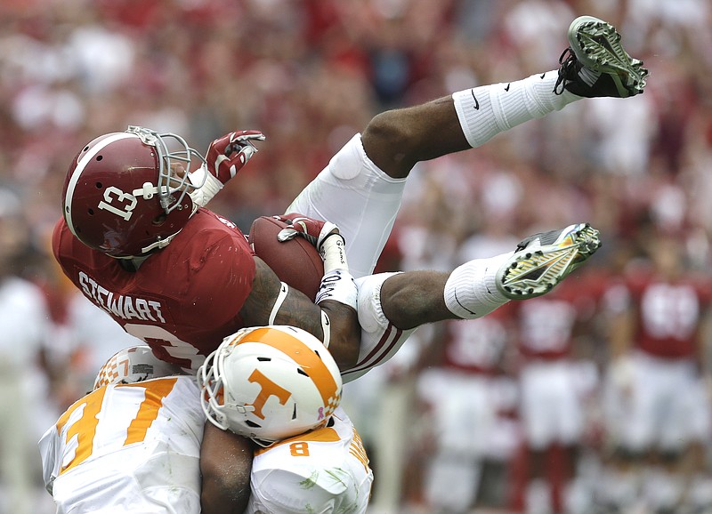 Alabama wide receiver ArDarius Stewart catches a pass as he comes down on top of Tennessee defensive backs Brian Randolph, left and Justin Martin during the second half of Saturday's game.