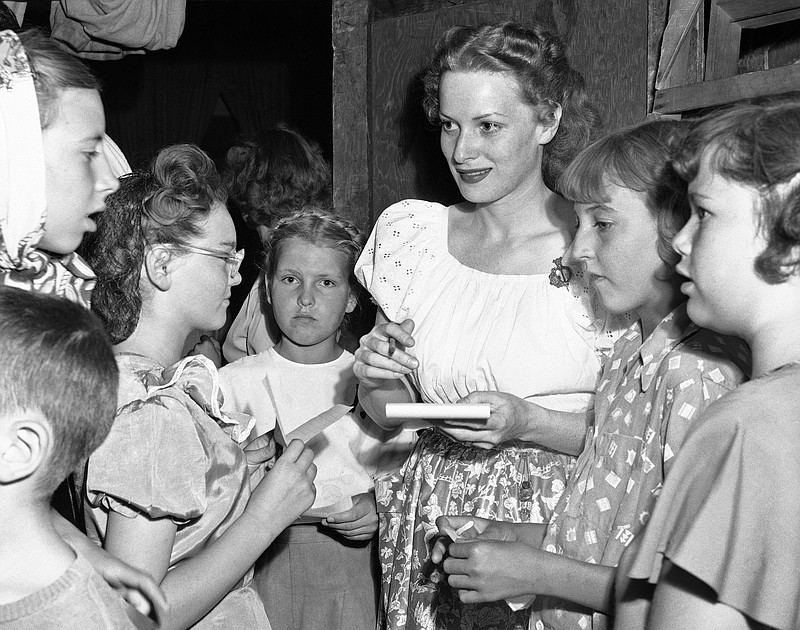 Maureen O'Hara signs autographs for school children of Moab, Utah, while on location there for a new film  in this 1950 file photo. O'Hara,who appeared in such classic films as "The Quiet Man" and How Green Was My Valley," has died. Her manager says O'Hara died in her sleep Saturday, Oct. 24, 2015 at her home in Boise, Idaho.