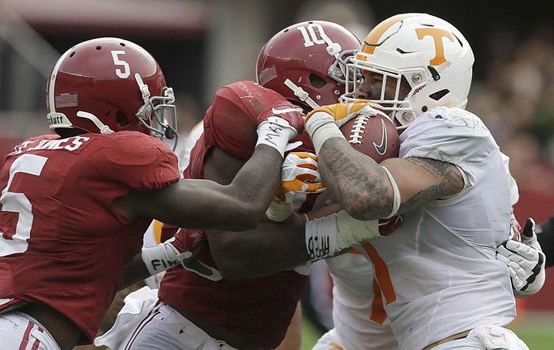Tennessee running back Jalen Hurd is stopped by Alabama linebacker Reuben Foster (10) and defensive back Cyrus Jones (5) during Saturday's game in Tuscaloosa. The Volunteers were frustrated on offense several times but managed to threaten the top 10-ranked Crimson Tide before losing 19-14.