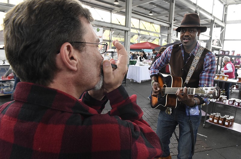 David Laudone, left, plays harmonica while Rick Rushing plays guitar at the Buskers Festival at the Chattanooga Market on Sunday, Oct. 25, 2015, in Chattanooga, Tenn. 