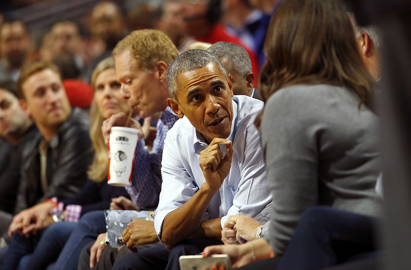 
              CORRECTS DAY OF WEEK TO TUESDAY NOT SATURDAY - President Barack Obama talks with fans during an NBA basketball game between the Cleveland Cavaliers and the Chicago Bulls in Chicago on Tuesday, Oct. 27, 2015. (AP Photo/Jeff Haynes)
            
